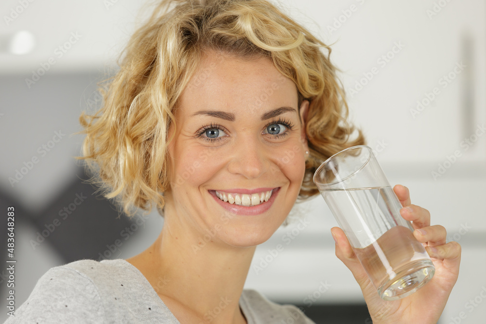 young woman drinking water from glass indoors young woman drinking water from glass indoors