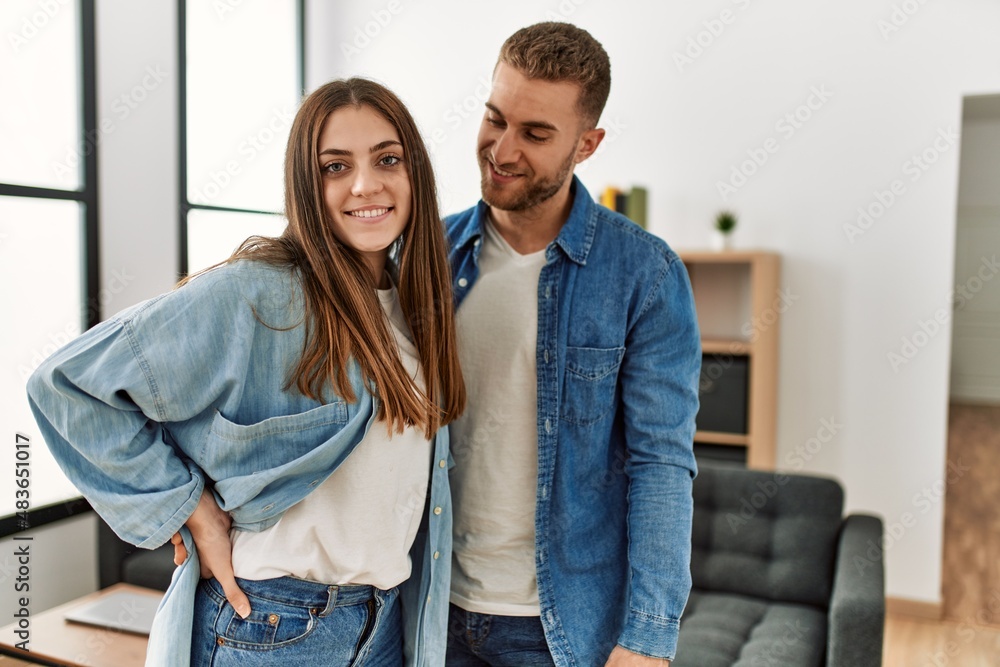 Young caucasian couple smiling happy standing at home.