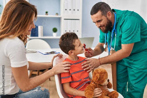 Family having medical consultation examining ear at clinic photo