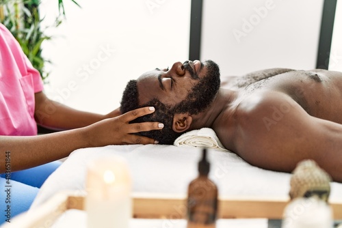 African american man reciving head massage at the clinic. photo