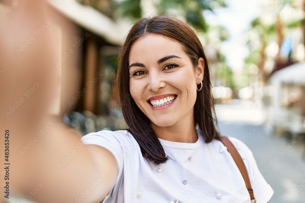 Young hispanic girl smiling happy standing at the city.