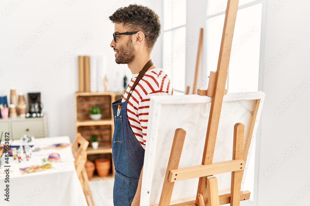 Arab young man at art studio looking to side, relax profile pose with natural face and confident smile. Arab young man at art studio looking to side, relax profile pose with natural face and confident smile.
