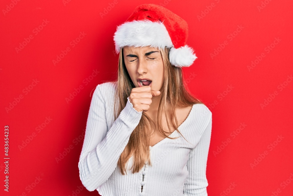 Beautiful hispanic woman wearing christmas hat feeling unwell and coughing as symptom for cold or bronchitis. health care concept. Beautiful hispanic woman wearing christmas hat feeling unwell and coughing as symptom for cold or bronchitis. health care concept.