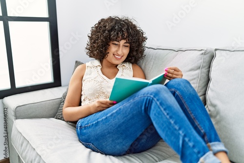 Young middle east woman smiling confident reading book at home