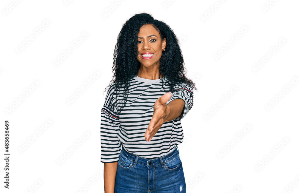 Middle age african american woman wearing casual clothes smiling friendly offering handshake as greeting and welcoming. successful business. Middle age african american woman wearing casual clothes smiling friendly offering handshake as greeting and welcoming. successful business.
