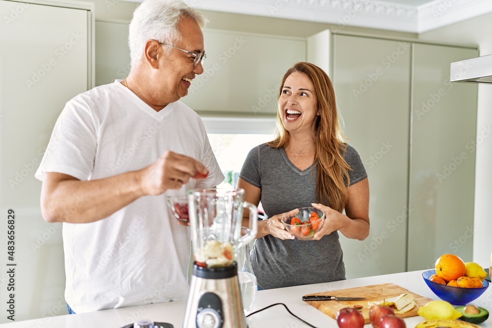 Middle age hispanic couple smiling happy cooking smoothie at the kitchen. Middle age hispanic couple smiling happy cooking smoothie at the kitchen.