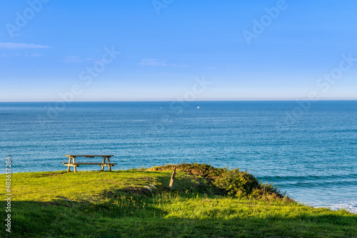 Solitary bench with afternoon light, Merón beach, near San Vicente de la Barquera, Cantabria, Spain. © mvera
