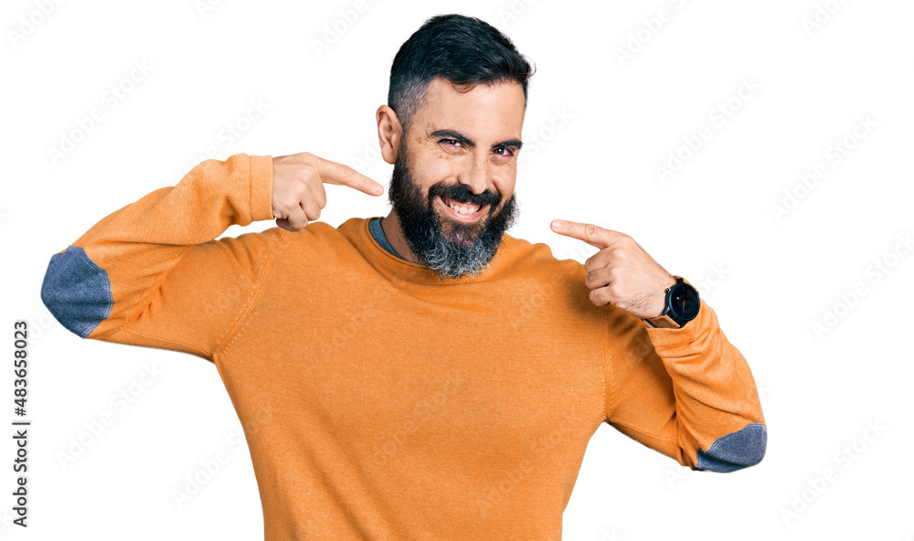 Hispanic man with beard wearing casual winter sweater smiling cheerful showing and pointing with fingers teeth and mouth. dental health concept. Hispanic man with beard wearing casual winter sweater smiling cheerful showing and pointing with fingers teeth and mouth. dental health concept.