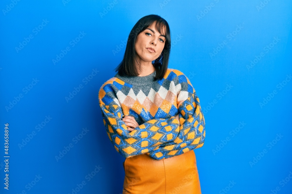 Young hispanic woman wearing casual winter sweater skeptic and nervous, disapproving expression on face with crossed arms. negative person. Young hispanic woman wearing casual winter sweater skeptic and nervous, disapproving expression on face with crossed arms. negative person.