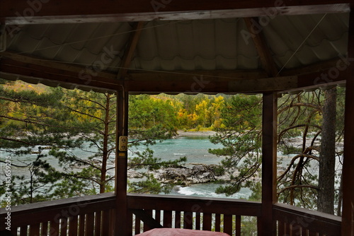 Russia. The South of Western Siberia, the Altai Mountains. Panoramic view of the Katun River through a wooden gazebo in a tourist campsite near the village of Manzherok. © Александр Катаржин