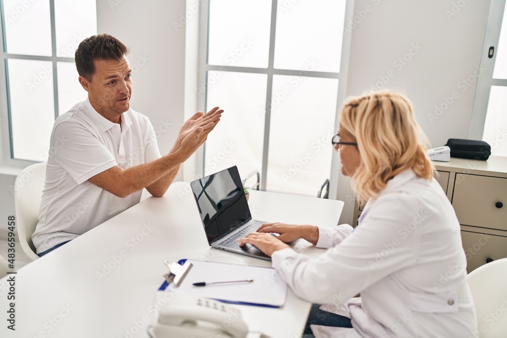 Middle age man and woman doctor and patient having medical consultation at clinic Middle age man and woman doctor and patient having medical consultation at clinic