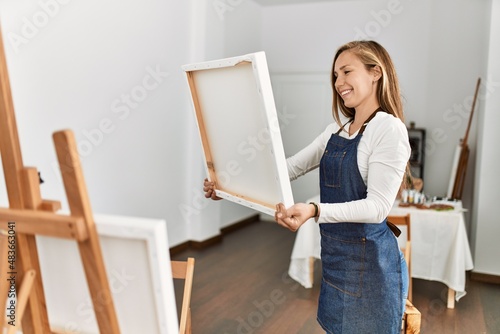 Young caucasian woman smiling confident looking canvas draw at art studio