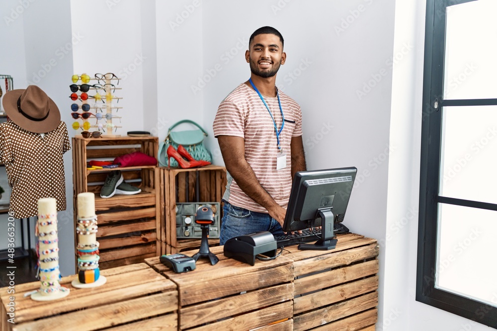 Young arab man smiling confident working at clothing store