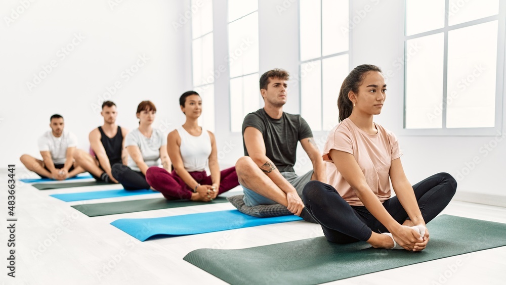 Group of young hispanic people concentrated training yoga at sport center. Group of young hispanic people concentrated training yoga at sport center.