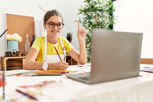 Adorable girl smiling confident having online draw lesson at art studio