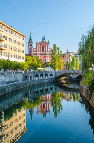 Franciscan Church of the Annunciation and Triple Bridge reflected in Ljublanica river, Ljubljana, Slovenia photo