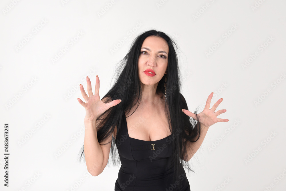 Portrait of a beautiful brunette woman in an explosive fighting pose ready to fight and scratch in hysterics with an evil face Portrait of a beautiful brunette woman in an explosive fighting pose ready to fight and scratch in hysterics with an evil face