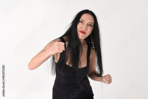 Obraz na płótnie Portrait of a beautiful brunette woman in an explosive fighting pose ready to fi