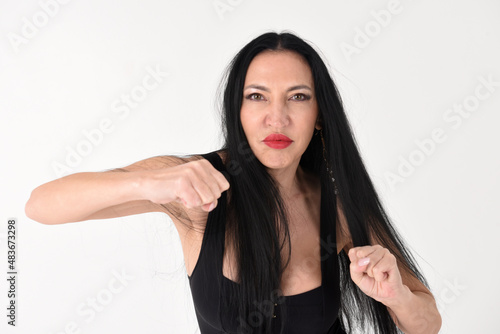 Fotografie Portrait of a beautiful brunette woman in an explosive fighting pose ready to fi