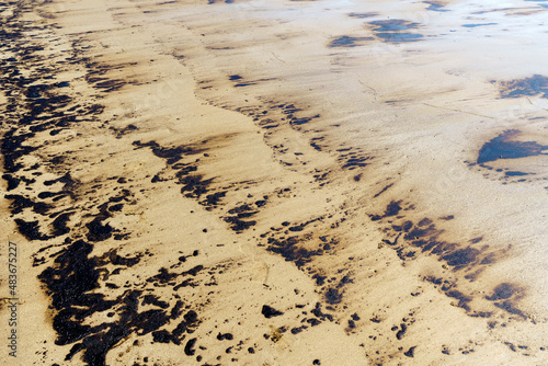 Texture of Crude Oil spill reaches shoreline from pipeline leak accident on Mae Ramphueng Beach, Rayong province, Thailand.