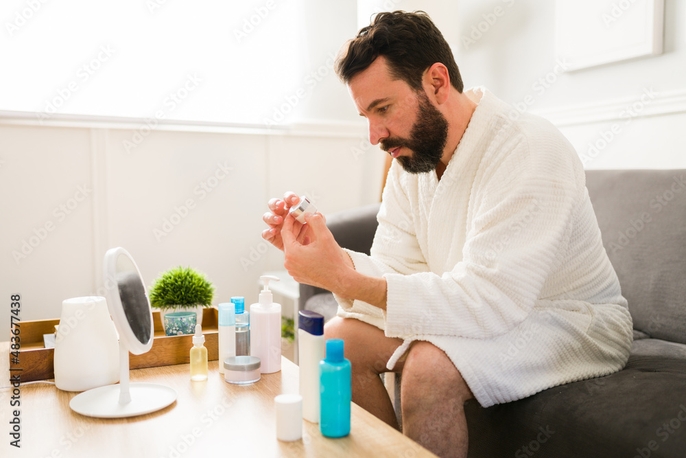Man on a white robe moisturizing Man on a white robe moisturizing