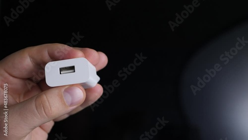 Wallpaper Mural Power socket with USB charger for smartphone in male hand on black background. White electrical connector, plastic device. Electrical plug device Torontodigital.ca
