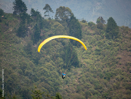 Yellow Paraglider Flying near the Green Mountains in Belmira, Antioquia, Colombia photo