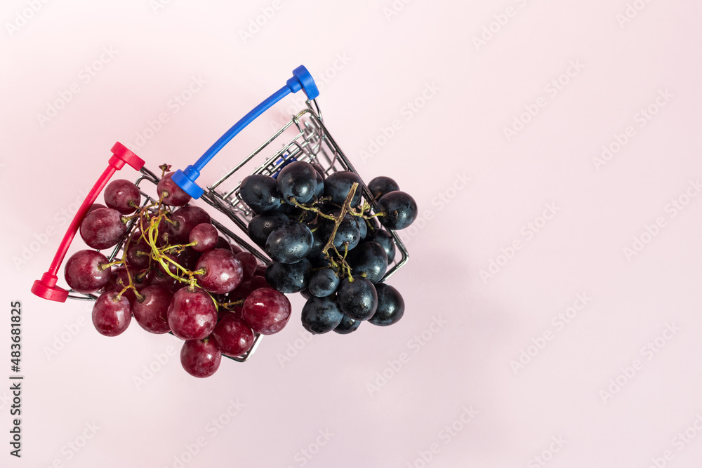 Grapes of red and black in grocery baskets top view. Grapes of red and black in grocery baskets top view.
