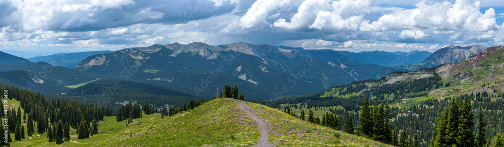 Storm Mountains - A panoramic view of Anthracite Range of West Elk Mountains, surrounded by dense evergreen forest, as seen from Scarp Ridge Trail on a stormy Summer day. Crested Butte, Colorado, USA. Storm Mountains - A panoramic view of Anthracite Range of West Elk Mountains, surrounded by dense evergreen forest, as seen from Scarp Ridge Trail on a stormy Summer day. Crested Butte, Colorado, USA.