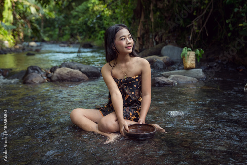 Beautiful young Asian girl rests and bathes in the river