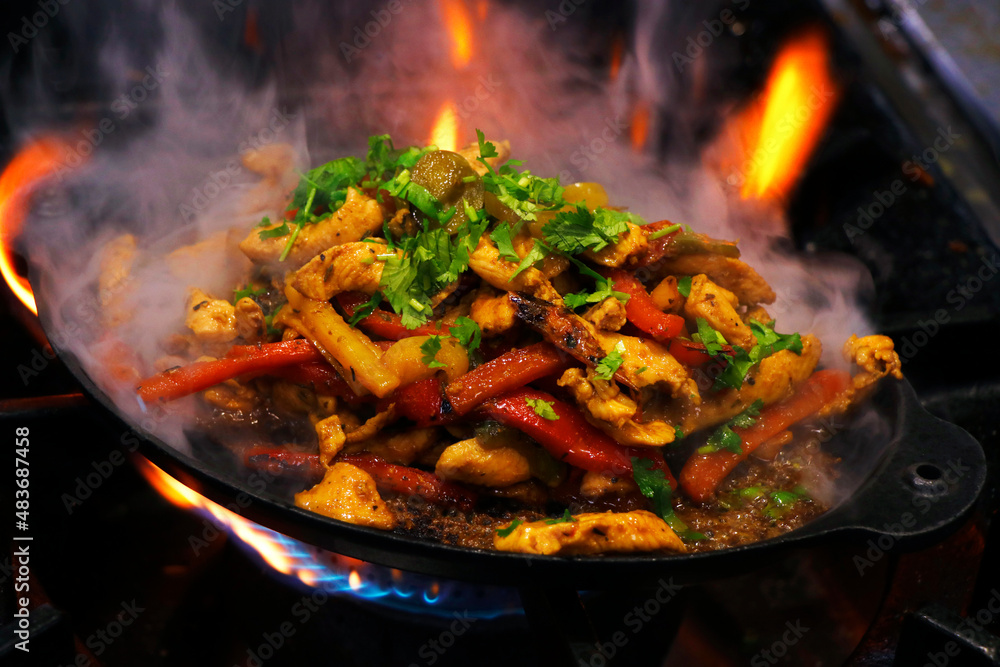 mexican food, chicken fajitas preparing on a hot smoking sizzling plate - obrazy, fototapety, plakaty 