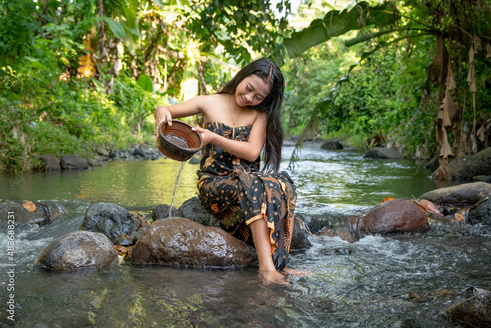 Beautiful young Asian girl rests and bathes in the river Beautiful young Asian girl rests and bathes in the river