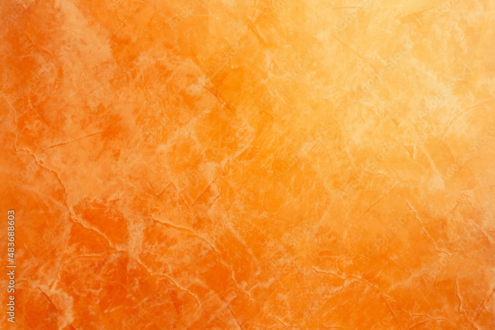 Orange surface with textured decorative plaster.
