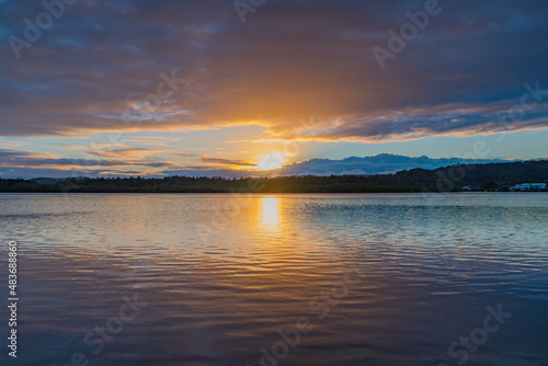 Sunrise waterscape with cloud covered sky