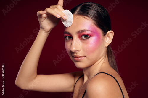 Beauty fashion female pink face makeup posing attractive look skin care pink background unaltered