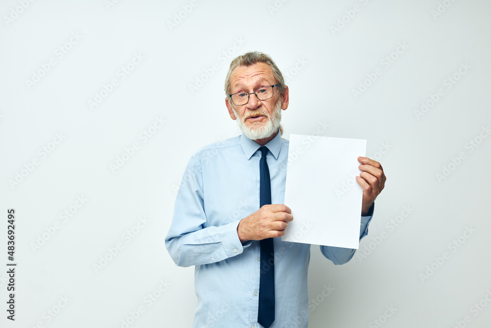 old man holding documents with a sheet of paper light background old man holding documents with a sheet of paper light background