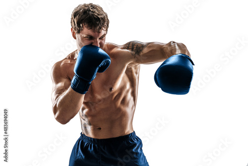 Portrait of muscular boxer who training and practicing left hook in blue gloves on white background. © zamuruev