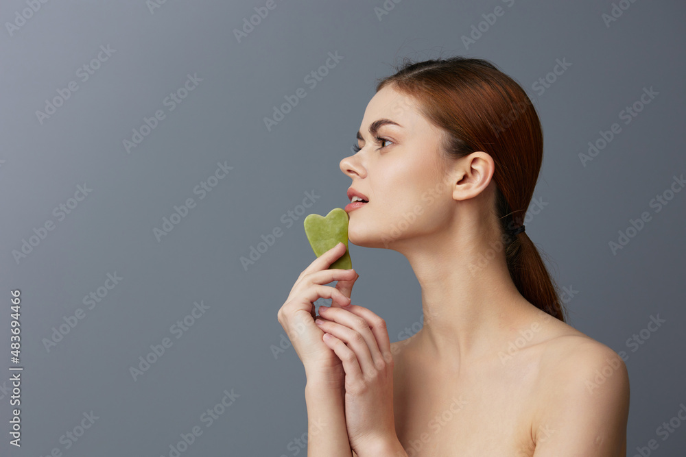 young woman facial scraper skin care posing isolated background young woman facial scraper skin care posing isolated background