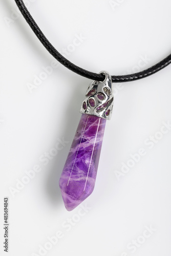 Amethyst pendant in silver on a black cord, isolated on white.