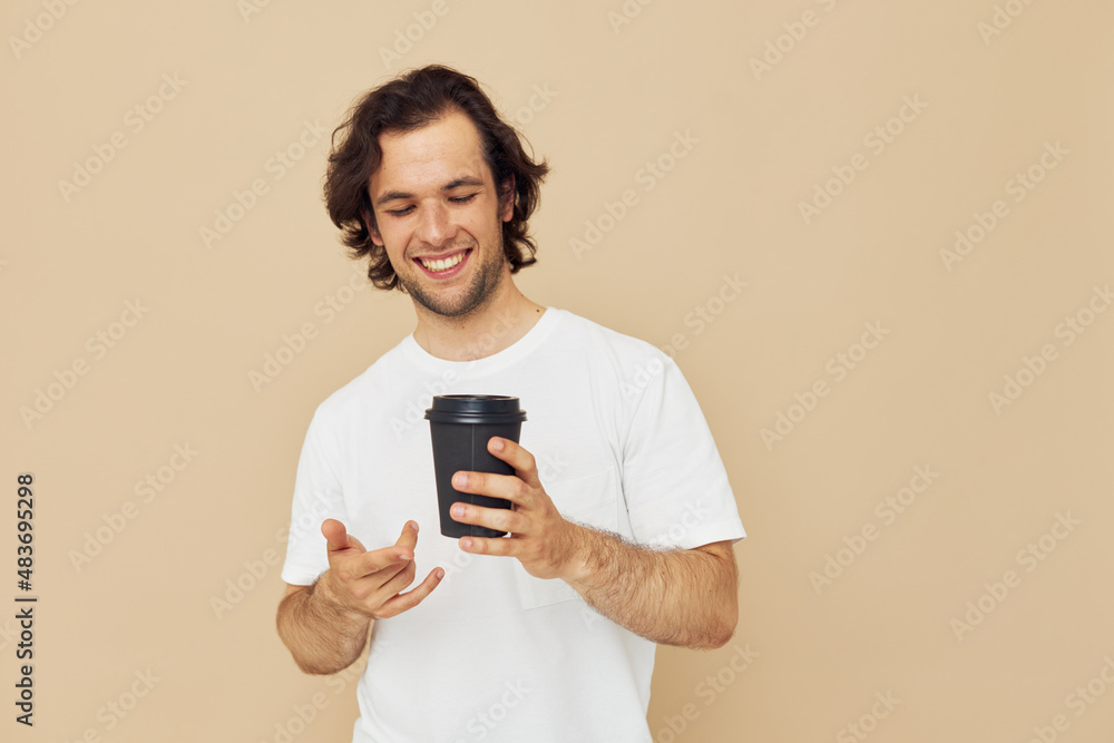 man in a white T-shirt with a black glass in hand Lifestyle unaltered man in a white T-shirt with a black glass in hand Lifestyle unaltered