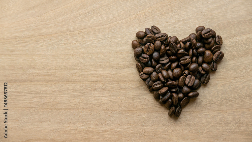 Coffee beans in heart shape on wooden background with copy space. Coffee beans in heart shape on wooden background with copy space.