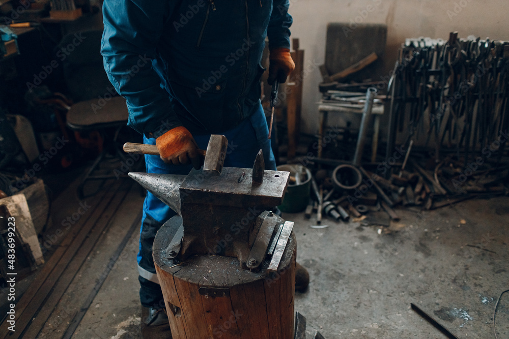 Blacksmith forges and making arrow arrowhead metal detail with hammer and anvil at forge. Blacksmith forges and making arrow arrowhead metal detail with hammer and anvil at forge.