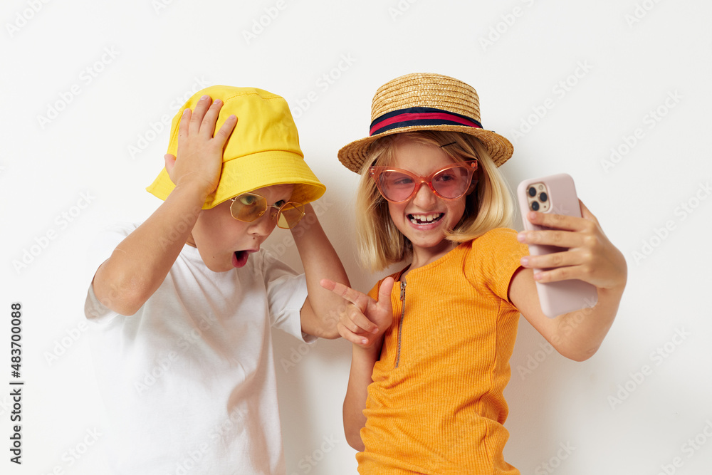children in hats with phone together friendship children in hats with phone together friendship