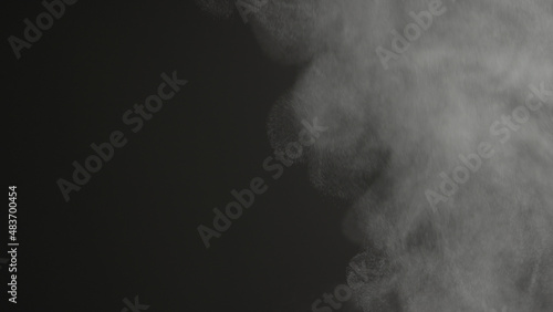 Steam rising over black background