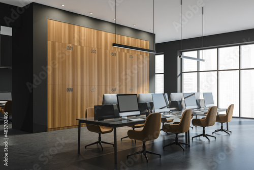 Corner view on dark office room interior with desktops