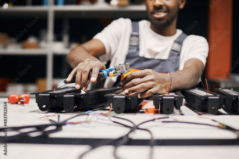 Man holding wires with tongs, working manually Man holding wires with tongs, working manually
