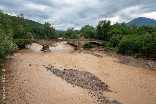 Old arch bridge over the Dakh River in the village of Dakhovskaya, Republic of Adygea, Russia photo