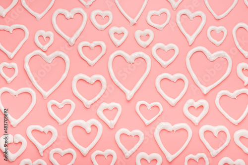 sweet meringue kiss cookies of heart shapes over pink background  concept of St. Valentines Day