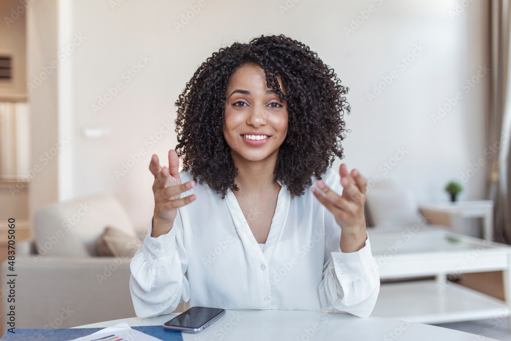 African-american elegant female entrepreneur discussing while having a conference call Portrait of confident ethnicity female employee looking at camera talking on video call in the home office. - obrazy, fototapety, plakaty 