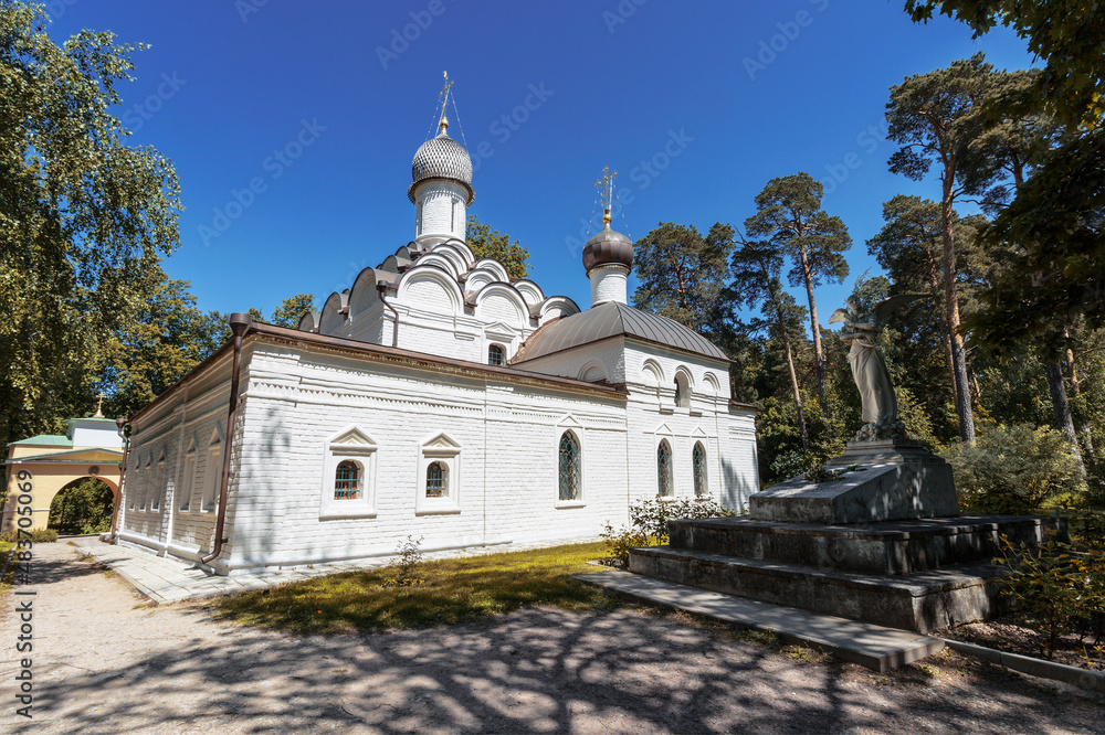 Church of the Archangel Michael and an angel sculpture at the grave of the young princess Tatyana Yusupova in the estate Arkhangelskoe. Moscow region, Russia